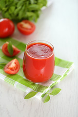 Tomato juice and fresh tomatoes on wooden table close-up