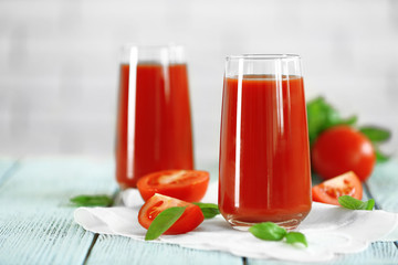 Tomato juice and fresh tomatoes on wooden table close-up