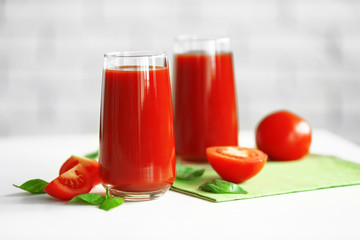 Tomato juice and fresh tomatoes on wooden table close-up