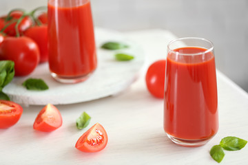 Tomato juice and fresh tomatoes on wooden table close-up