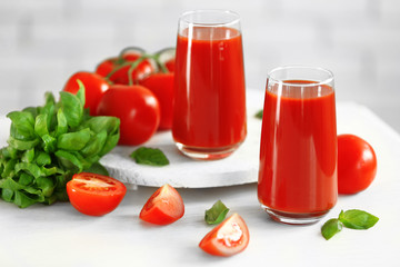 Tomato juice and fresh tomatoes on wooden table close-up