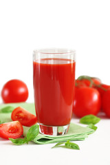 Tomato juice and fresh tomatoes on wooden table close-up