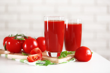 Tomato juice and fresh tomatoes on wooden table close-up