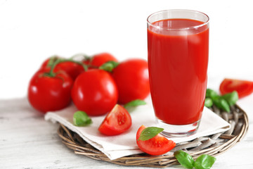 Tomato juice and fresh tomatoes on wooden table close-up