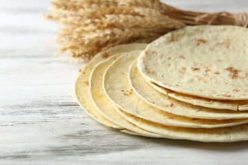 Stack of homemade whole wheat flour tortilla on wooden table background