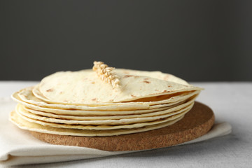 Stack of homemade whole wheat flour tortilla on napkin, on  dark background