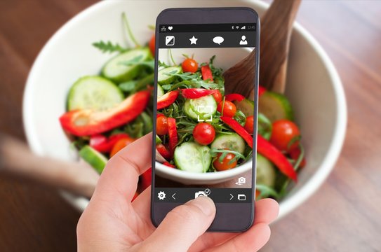 Composite image of female hand holding a smartphone