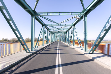 Photo of a long steel bridge over Odra river in Gryfino, Poland.