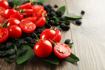 Cherry tomatoes with raisins on wooden background
