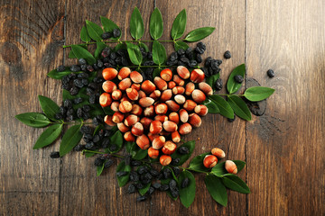 Hazelnuts with raisins arranged in heart shape on wooden background