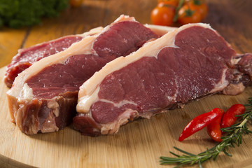 raw meat : fresh beef fillet with garlic and green stuff on wood