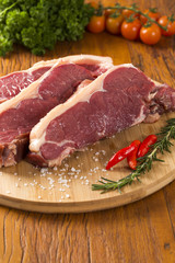 raw meat : fresh beef fillet with garlic and green stuff on wood