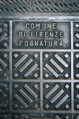 Florence manhole cover. Detail from a manhole cover in the Italian town of Firenze (Florence). 'Comune di Firenze Fognatura' translates to 'Town of Florence Sewer'.