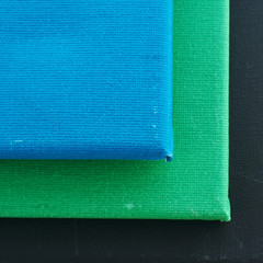 Art canvas  background with pile of blue, green and black canvas, square