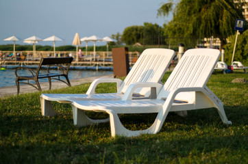 Fototapeta premium Two white chairs at the beach in the summer. Travel concept