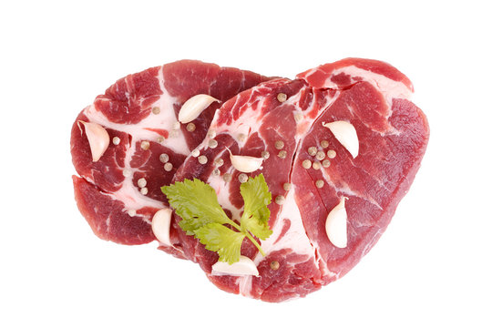 raw steaks of pork neck seasoned with pepper and garlic.