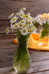 Beautiful flowers in vases on table close up