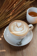 Cup of latte coffee on wooden table