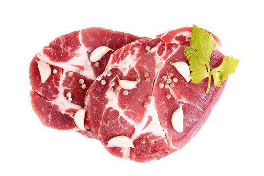 raw steaks of pork neck seasoned with pepper and garlic