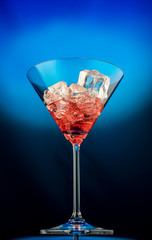 Martini glass with ice on a blue background