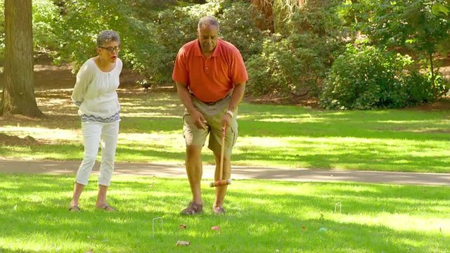 Mature Black Friends Playing Croquet Outside in a Park