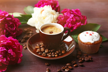 Composition with cup of coffee, muffins and peony flowers on wooden background