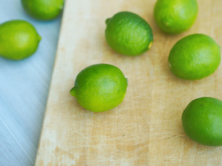 Whole limes closeup on wooden cutting board