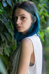 Blue haired girl posing on the background of ivy