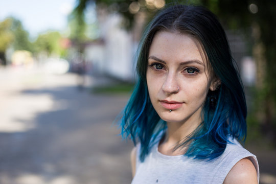 Blue haired girl posing on the background of ivy