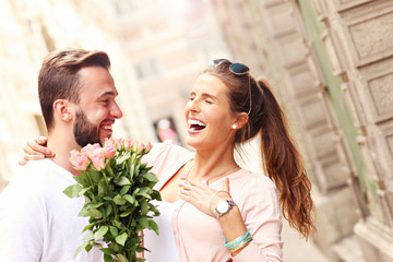 Joyful romantic couple with flowers