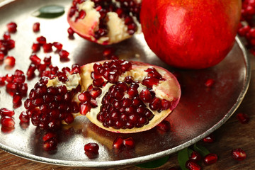 Pomegranate seeds on metal tray, closeup