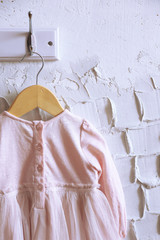 Fototapeta na wymiar Child dress on hanger on white wall background