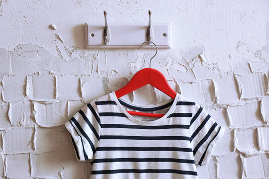 Child dress on hanger on white wall background