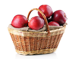 Red apples in wicker basket isolate on white
