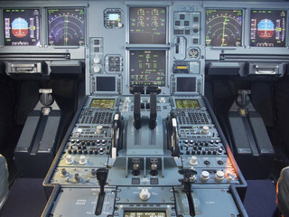 Airbus A330 airplane's cockpit front and pedestrian panel taken on ground at day time. The aircraft is parked at parking stand during sunny day while no pilots at seats. All lcd displays are turn on. © weerawath
