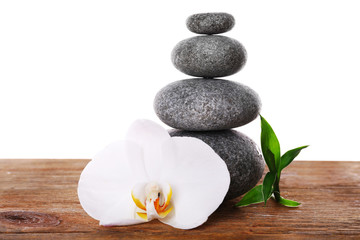 Fototapeta na wymiar Stack of spa stones with orchid flower isolated on white
