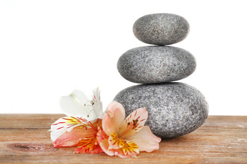 Fototapeta na wymiar Stack of spa stones with flower isolated on white
