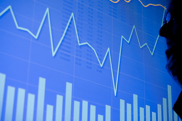 A man examining a business chart on an LCD screen. Could also be a scientific graph.
