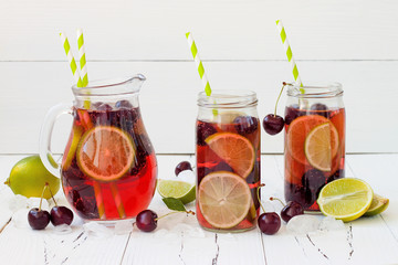 Lime and ice close up on dark wooden table. Detox citrus infused flavored water on dark wooden background. Refreshing summer homemade cocktail with lemon, lime, orange and grapefruit