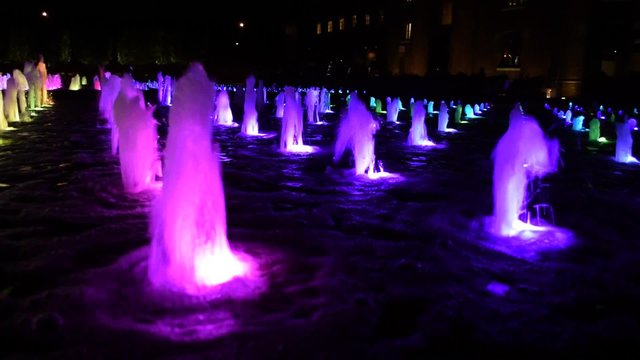 Colourful water feature (dancing fountain) at night in London, England