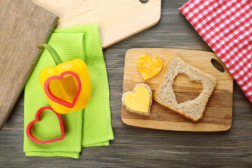 Bread slice with cut in shape of heart and pepper on table close up