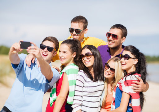 group of friends taking selfie with cell phone