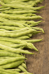 small and slender green beans (haricot vert) on a wood