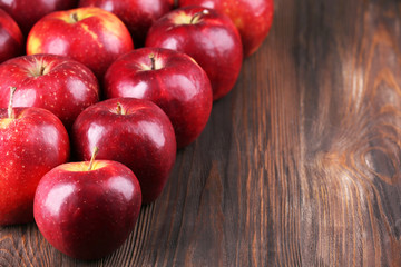 Heap of ripe red apples on wooden background