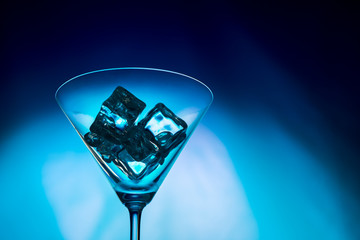 ice cubes in a glass on a blue background