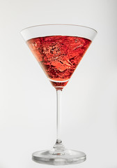 Glass of red martini on a white background