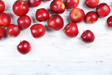 Heap of ripe red apples on wooden background