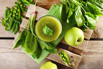 Glass of green healthy juice with spinach and apple on table close up