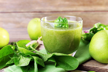 Glass of green healthy juice with spinach and apple on table close up