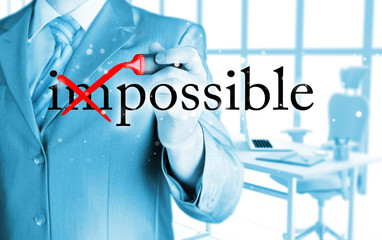 Businessman Hand turning the word Impossible into Possible with